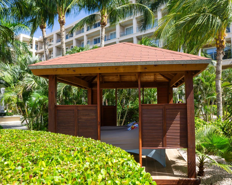 Wooden treatment cabana set among tropical planting in the grounds at Le Vent Condominiums.