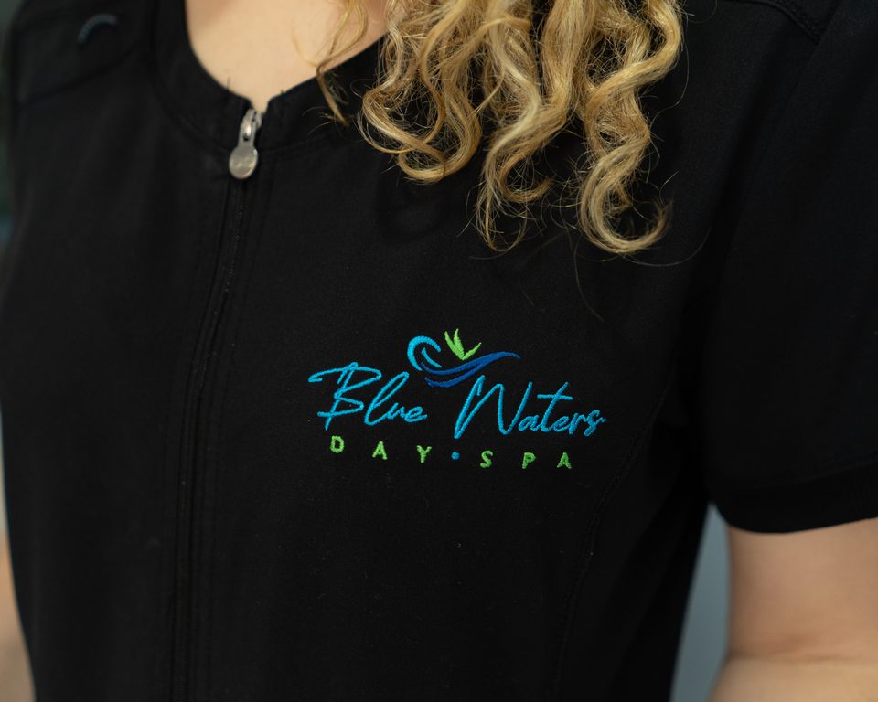 Close view of the embroidered Blue Waters Day Spa logo on a staff uniform.